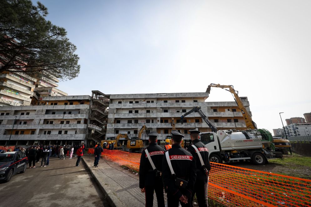 Restart Scampia, il grande progetto di riqualificazione urbana del quartiere dell’estrema periferia nord di Napoli, ha subito un’accelerazione l’estate scorsa, quando un crollo avvenuto nella Vela celeste ha causato la morte di tre persone e il ferimento di un’altra decina. Per quella tragedia, la Procura di Napoli ha iscritto nel registro degli indagati 12 funzionari pubblici del Comune e della partecipata Napoli Servizi per crollo colposo, omicidio plurimo colposo e lesioni colpose