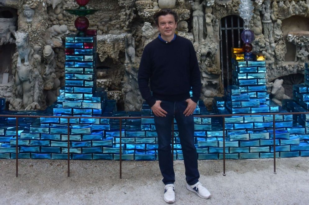 Il sogno di una vita…  - Per celebrare i 110 anni del capolavoro, i responsabili del Palazzo ideale, sito gestito oggi come un museo, hanno puntato non a caso su Jean-Michel Othoniel. Lo scultore-decoratore, noto ad esempio per aver realizzato a Parigi un centralissimo ingresso policromo della metropolitana, è un nativo della regione del Palazzo ideale. Da ragazzo, veniva spesso a visitare il monumento, rimasto sempre da allora una fonte d’ispirazione per l’artista. Nonostante le tante mostre prestigiose realizzate in tutto il mondo, Othoniel non ha mai smesso di riflettere sulle motivazioni profonde che hanno spinto il postino Cheval a spendere buona parte della propria vita in un’impresa che a non pochi potrebbe apparire quasi insensata, ma di cui, dopo oltre un secolo, si continua ad ammirare il genio recondito. Cheval lavorò al suo capolavoro unico per 33 anni dopo essere inciampato un giorno su una pietra d’eccezionale suggestione. Ma Othoniel, 58enne, ha in qualche modo ‘lavorato’ con l’immaginazione per un tempo ancor più lungo fino al cantiere sfociato nell’attuale mostra. Quest’ultimo può apparire come una sorta d’intimo coronamento personale, oltre che strettamente artistico.