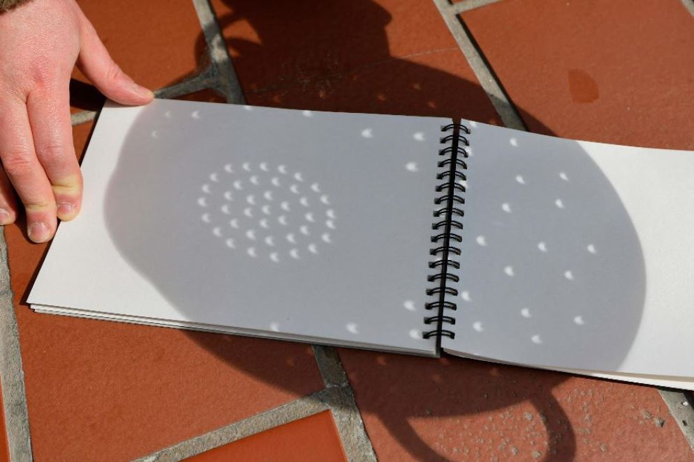 Foglio di carta e scolapasta per questa osservazione indiretta artigianale dell'eclissi dal Rockfeller Center di New York