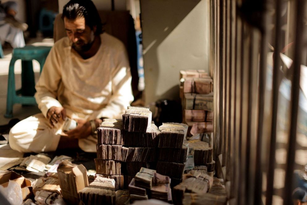 Questo è quello che a Kabul viene definito un negozio di cambia valute: cumuli di banconote, che valgono ormai poco, in un angolo di un mercato