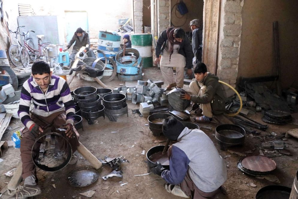 Giovani afghani costruiscono stufe artigianali a Kandahar