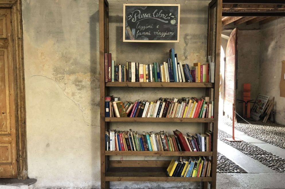 Scaffali in legno sotto il portico di Cascina Cuccagna a Milano