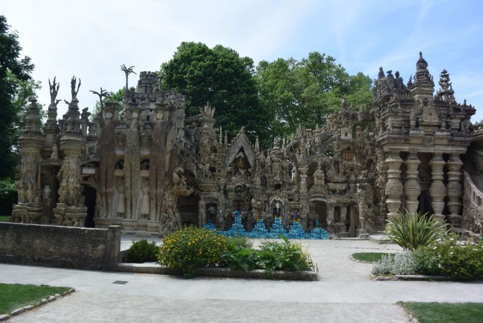 La facciata principale - La facciata principale impressiona per la sovrapposizione armoniosa di motivi simbolici tratti dalle grandi narrazioni di tutti i tempi, compresi diversi temi biblici. Ad alcuni, il Palazzo ideale ricorda il genio dell’architetto catalano Antoni Gaudí (1852-1926), contemporaneo di Cheval. Ad altri, l’arte africana o dell’Estremo Oriente. Fra i grandi estimatori dell’opera unica di Ferdinand Cheval, vi era pure Pablo Picasso. Oggi, per la prima volta nella storia del Palazzo, la sfida lanciata dal postino delle meraviglie è stata raccolta da un noto artista francese, lo scultore-decoratore Jean-Michel Othoniel (58 anni), che ha incastonato o giustapposto al palazzo le proprie creazioni policrome in vetro soffiato, traendo ispirazione dall’incredibile epopea di costruzione del monumento. Un modo inedito per festeggiare i 110 del capolavoro.