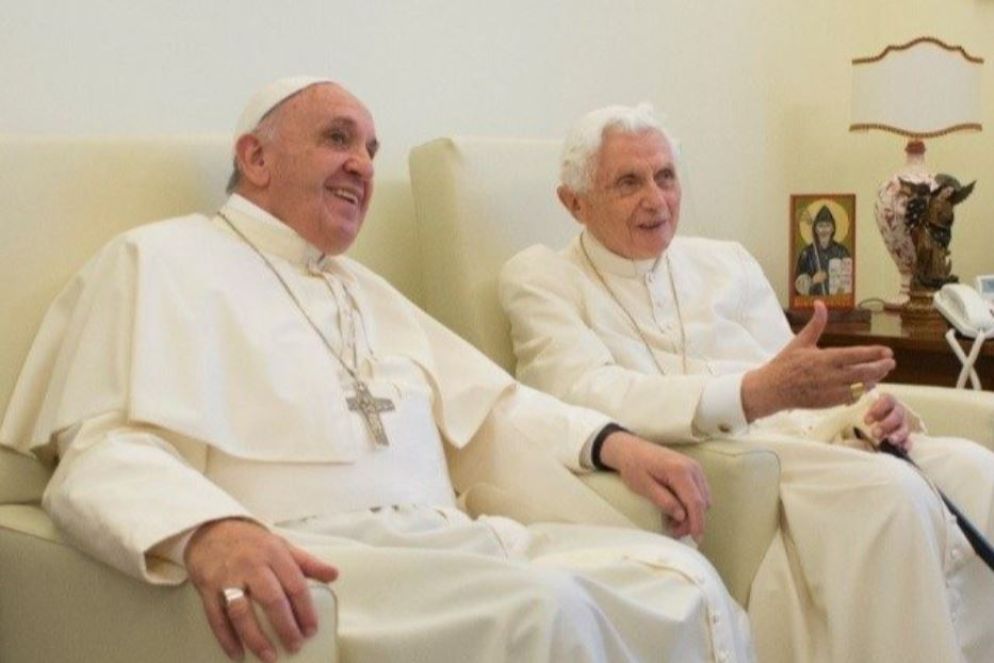 Il monastero Mater Ecclesiae è stata la residenza di Benedetto XVI dopo la sua rinuncia al ministero petrino. Qui ha condotto la sua vita ritirata in preghiera e in studio. E qui papa Francesco gli ha fatto spesso visita, specialmente in occasioni particolari come le festività. La fotografia ritrae proprio uno di questi momenti. “È come avere in casa un nonno saggio” ebbe a rispondere Francesco ai giornalisti che gli chiedevano i suoi rapporti con il predecessore in questa insolita “convivenza”. E Bergoglio non ha mancato mai occasione per esprimere il proprio affetto a Ratzinger.