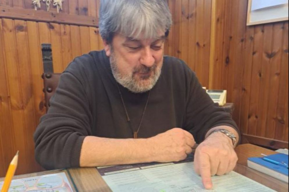 Frate Arturo Busetti, cappellano della chiesa del Cimitero Monumentale di Milano, davanti alla mappa del cimitero - .