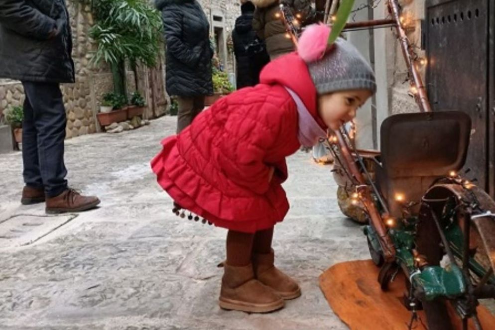 Una bambina osserva con curiosità uno dei presepi allestiti lungo le strade di Portico di Romagna - .