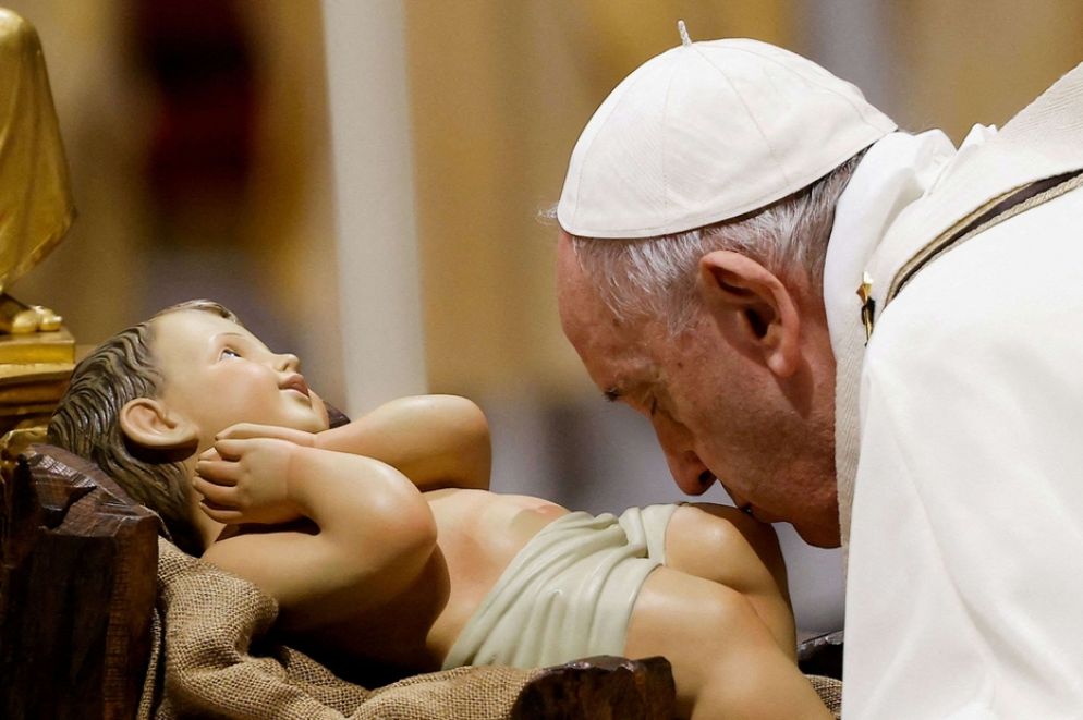 Il bacio del Papa a Gesù Bambino nella Messa della notte di Natale - Reuters