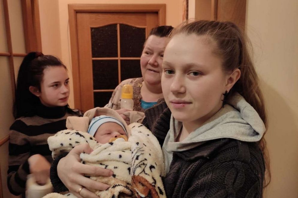 una giovane tiene in braccio il bimbo che ha solo 18 giorni, tratto in salvo dal sacerdote salesiano - .