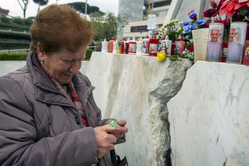 Una donna accende una candela - .
