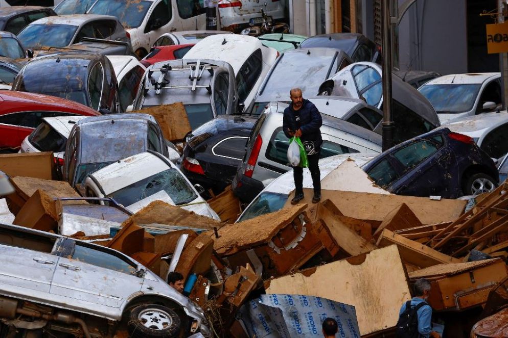 Le persone si muovono stralunate tra pile di automobili per le strade di Valencia - Reuters