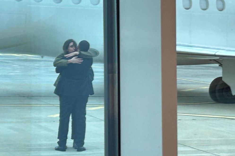 L'altro abbraccio al compagno Daniele, appena atterrata, colto dai fotoreporter da una finestra del terminal di Ciampino - Ansa