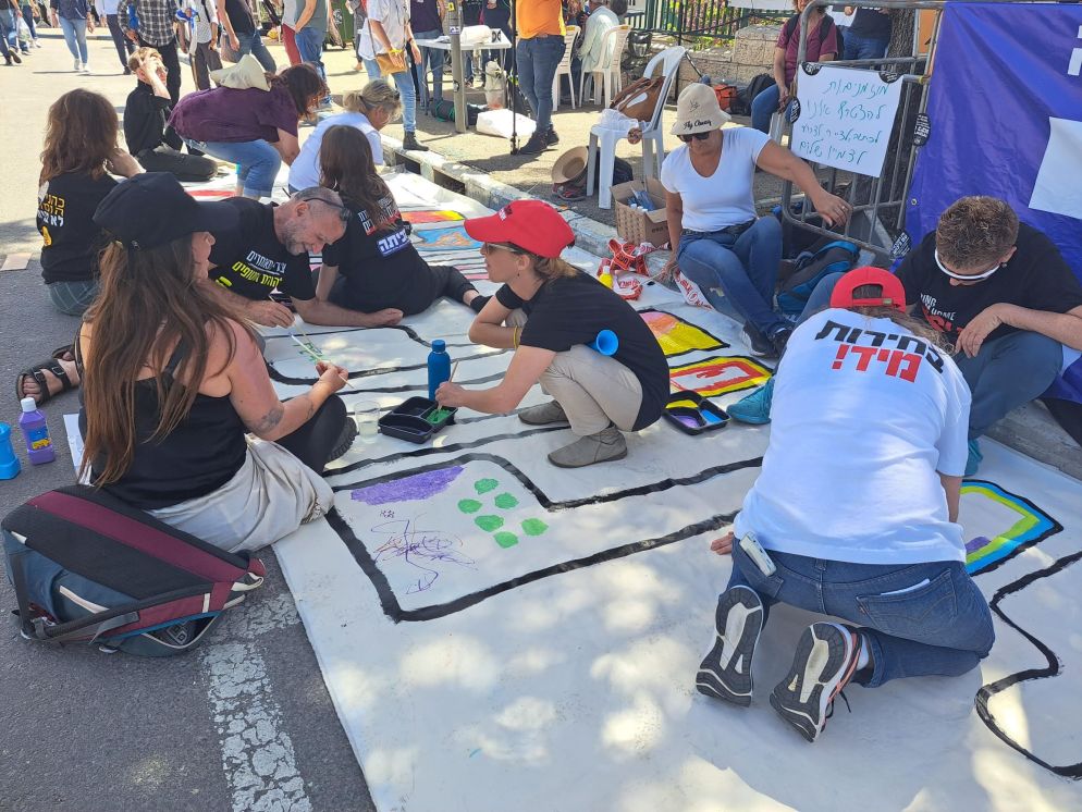 Ragazzi di vari gruppi pacifisti scrivono la parola "shalom", pace
