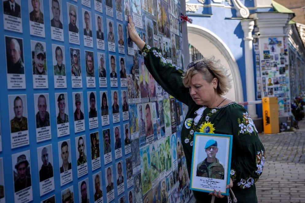 Una donna piange il figlio davanti al Memoriale delle vittime di guerra a Kiev