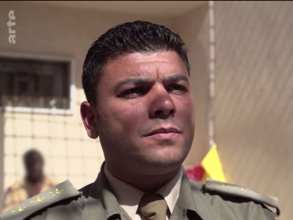 Il capitano Bashir al Jahni. Capo dei guardiani delle prigioni del generale Haftar, in un frame di una intervista del 2019 - Arte