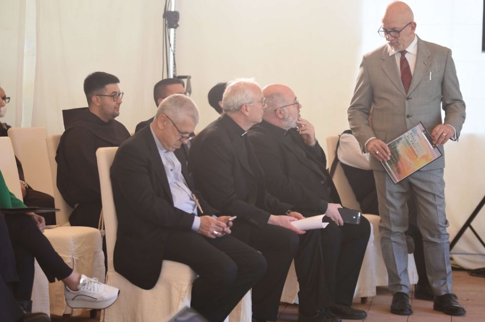 Goianno Cervellera, conduttore delle sessioni plenarie, dialoga con don Massimo Angelelli e l'arcivescovo di Cagliari Giuseppe Baturi - Foto Carla Picciau